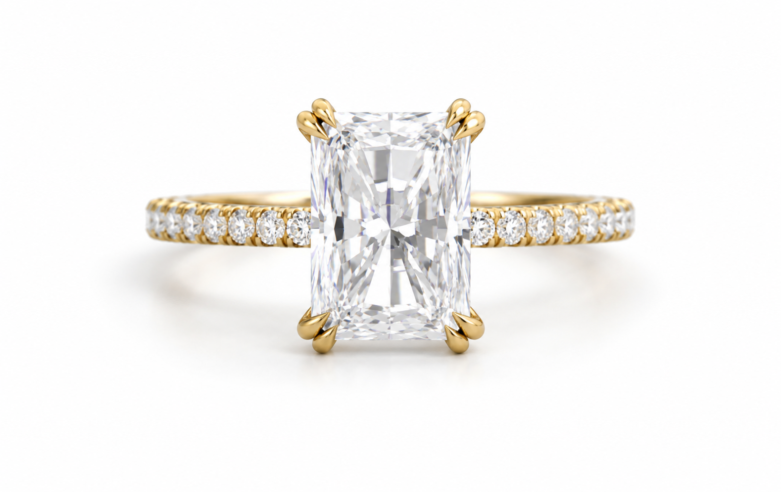 A yellow gold engagement ring featuring a large rectangular emerald-cut diamond center stone and a pavé diamond band, set against a clean white background.