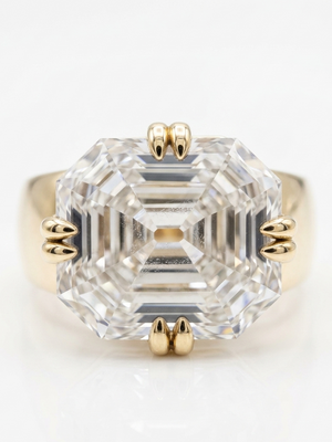 Gold ring with a large clear gemstone on a white background