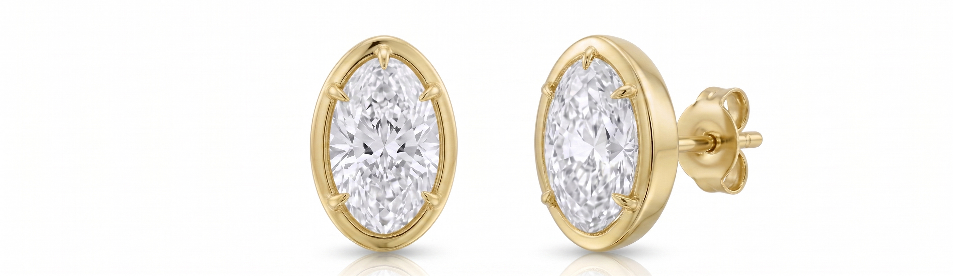 Gold earrings with clear gemstones on a white background