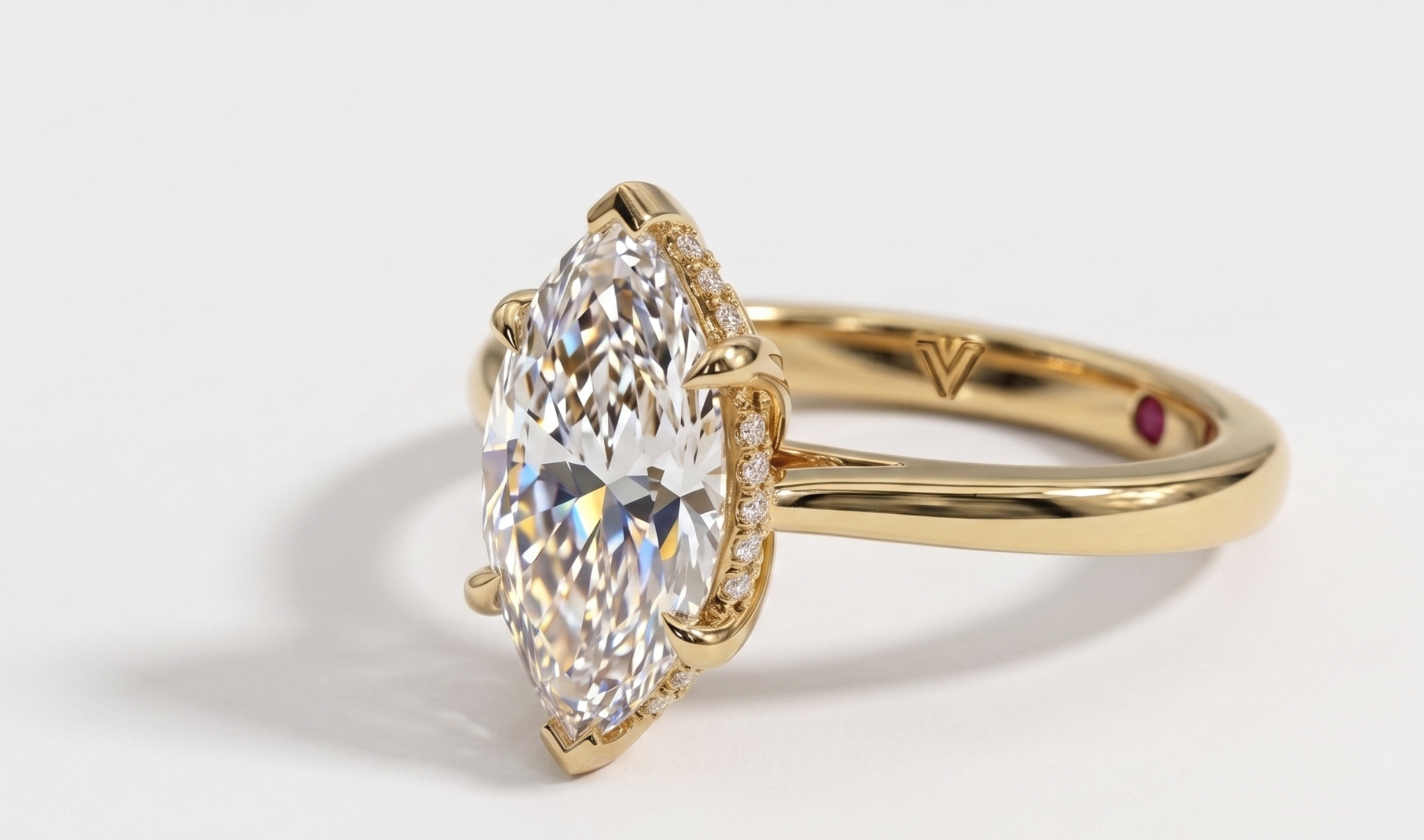 A close-up lifestyle shot of a person's hands resting on a cream napkin at a wooden table, holding a cup of espresso. The person is wearing a gold ring with a marquise-cut clear gemstone.