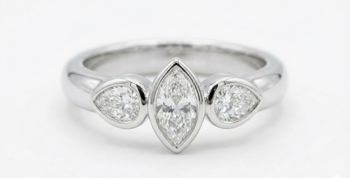 Silver ring with three pear-shaped diamonds on a white background